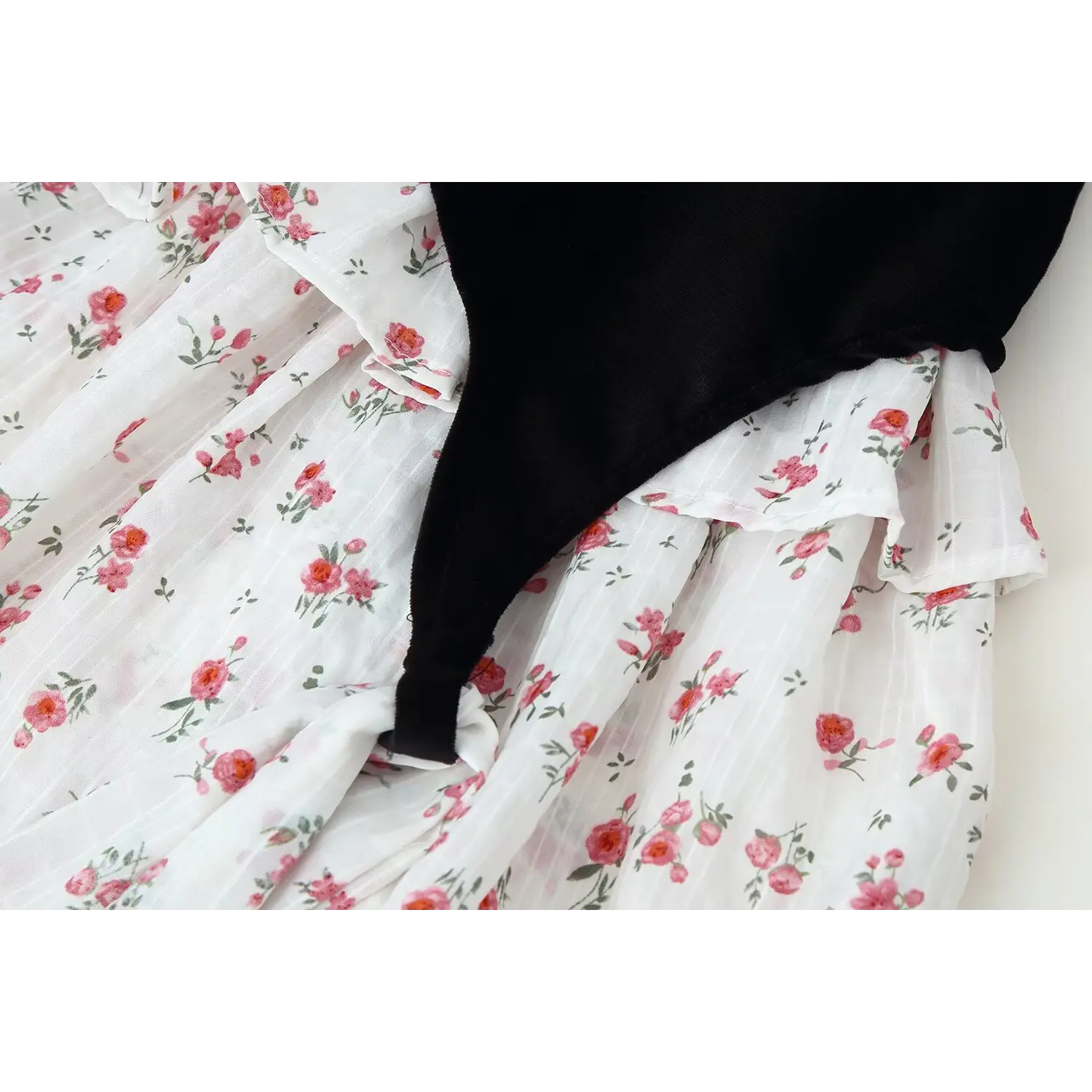 Close‑up of white base pink floral print tiered ruffle skirt, mixed velvet and floral fabric splicing detail