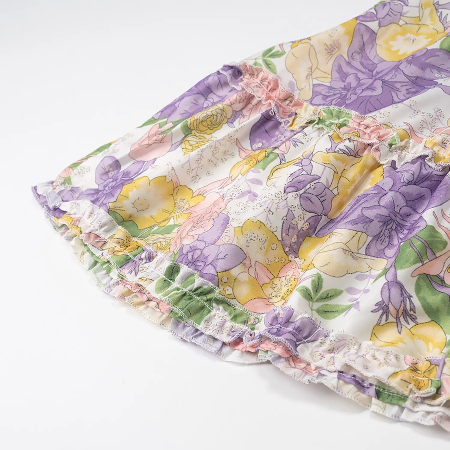 Detail shot of ruffled tier skirt hem on vintage floral print short dress with mixed pastel blooms
