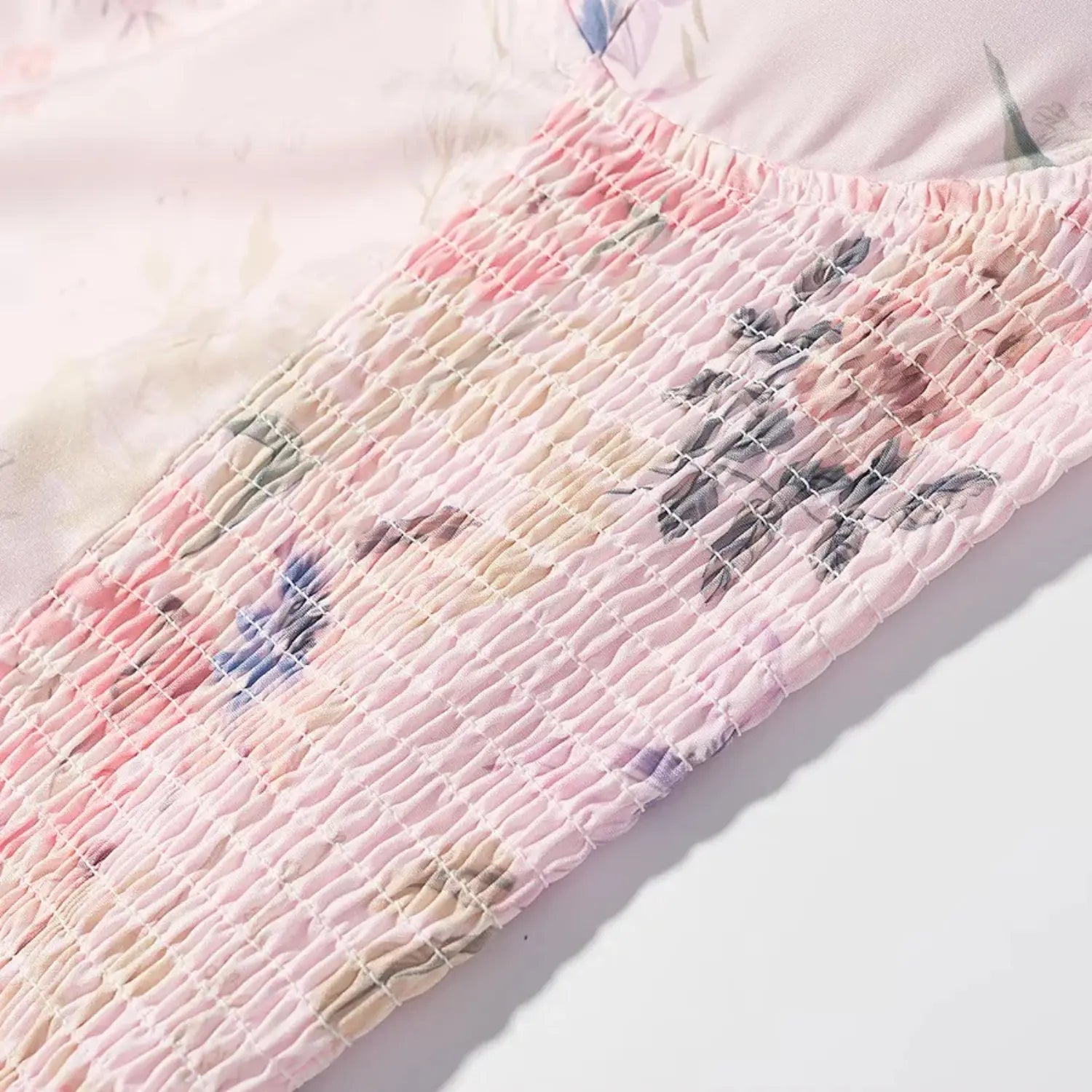 Draped fabric texture shot, matte lightweight woven material, soft watercolor pink and purple flower pattern
