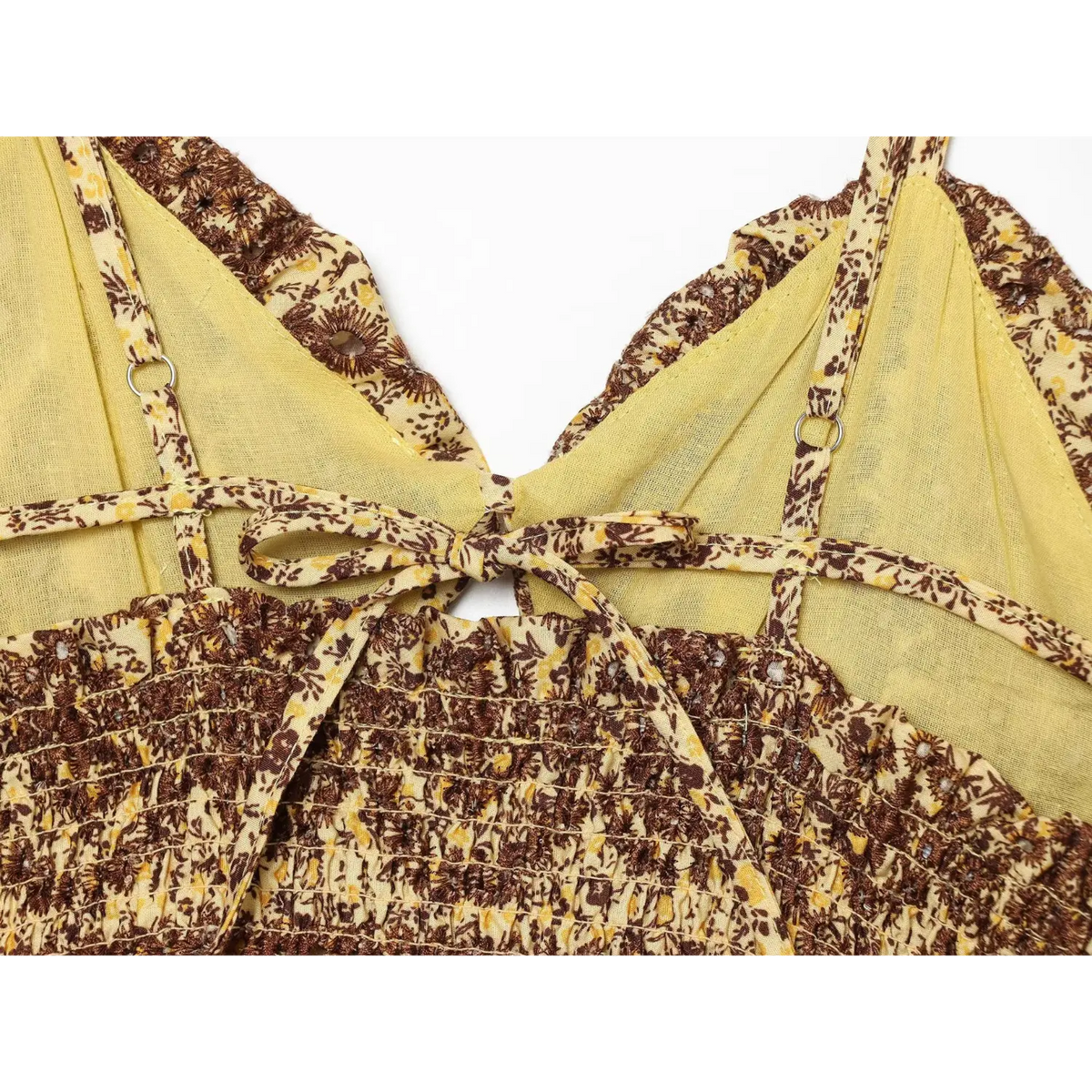 Close‑up of back tie and adjustable spaghetti strap hardware on yellow brown floral dress