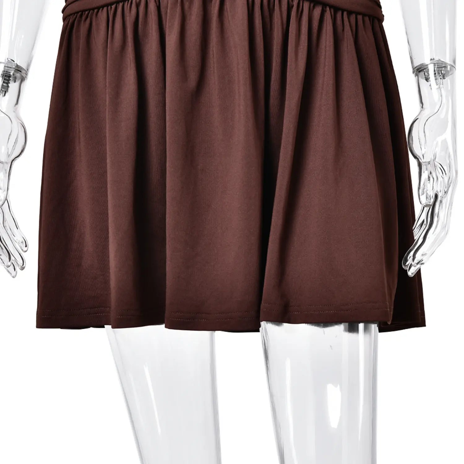 Side closeup of loose swing skirt hem, solid brown halter mini dress