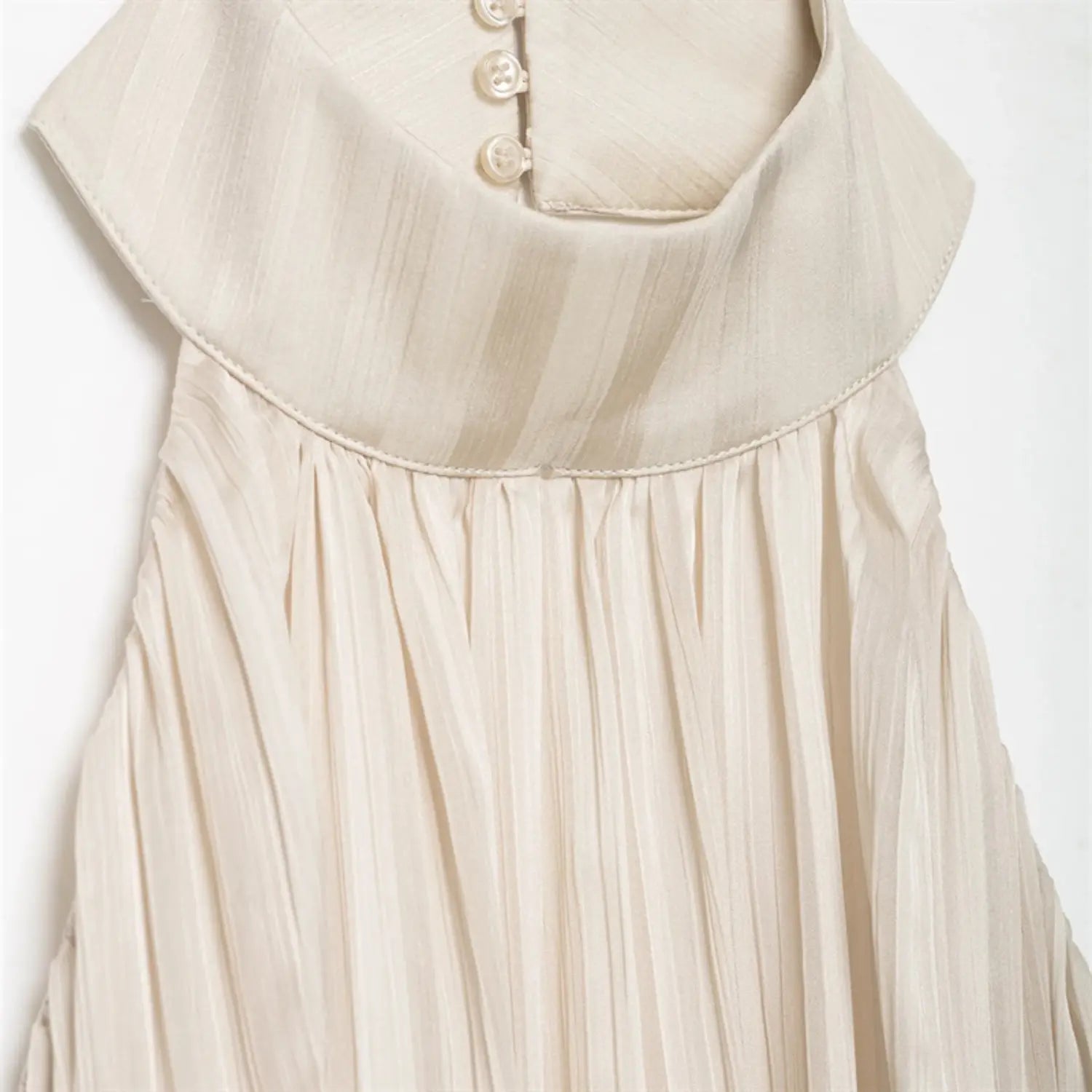 Macro shot of folded halter collar, vertical three pearl buttons on back keyhole placket