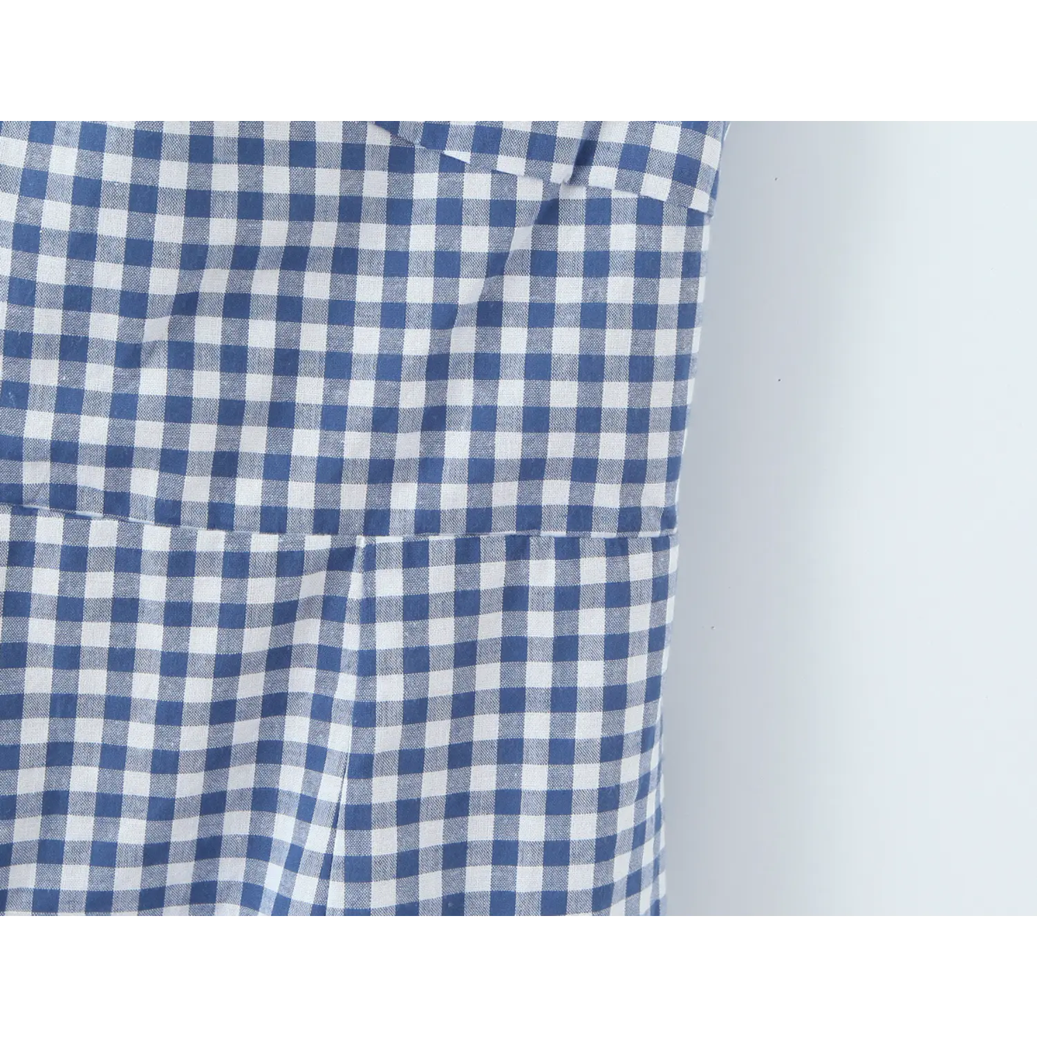 Folded off shoulder flutter sleeve macro close-up, double folded sleeve panel natural shoulder coverage fully bound shoulder seam lightweight check fabric detail shot