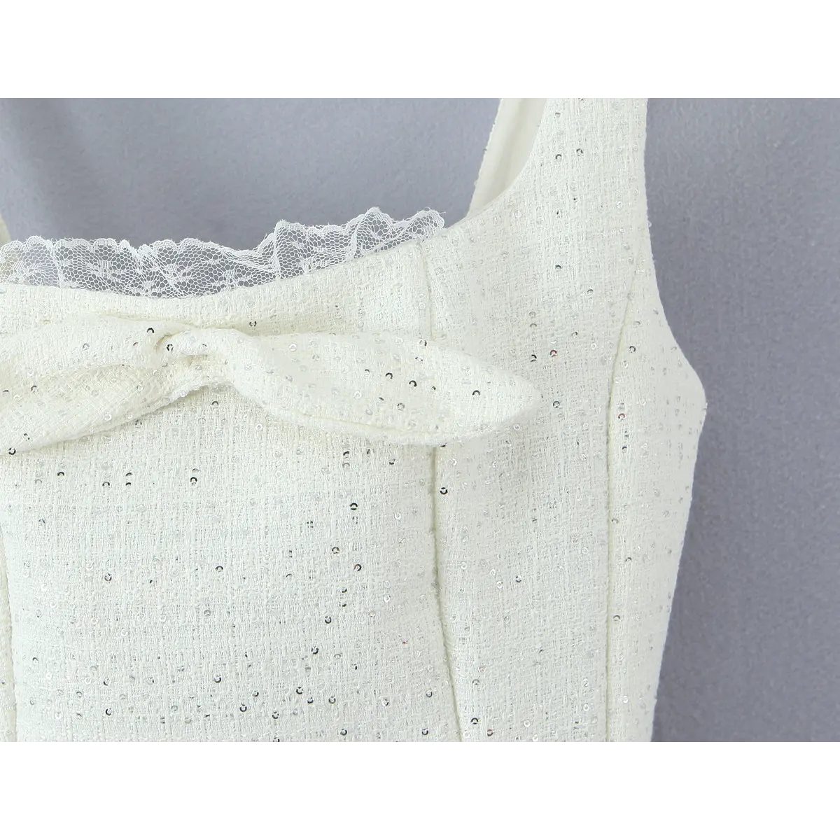 Upper bust close, self-fabric front bow decoration, scattered shiny sequins on textured tweed cloth, inner lace neck lining.