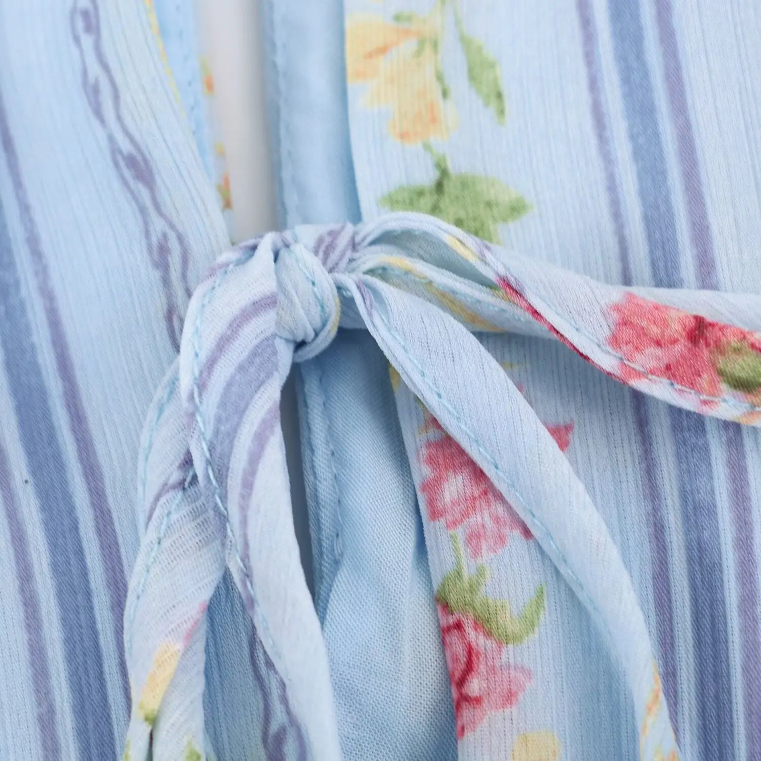 Front hollow keyhole self tie bow close-up, same vertical stripe pink blossom printed crinkle fabric, neat serged edge stitching
