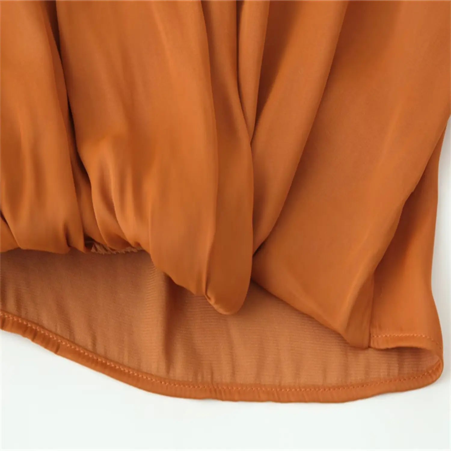 Detail of overlapping draped front panels creating deep wrap effect, soft flowing fabric folds