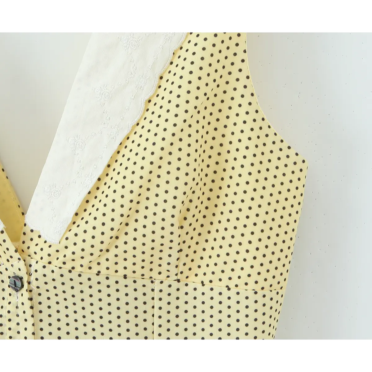 Decor round button stitching close on yellow dot dress bust