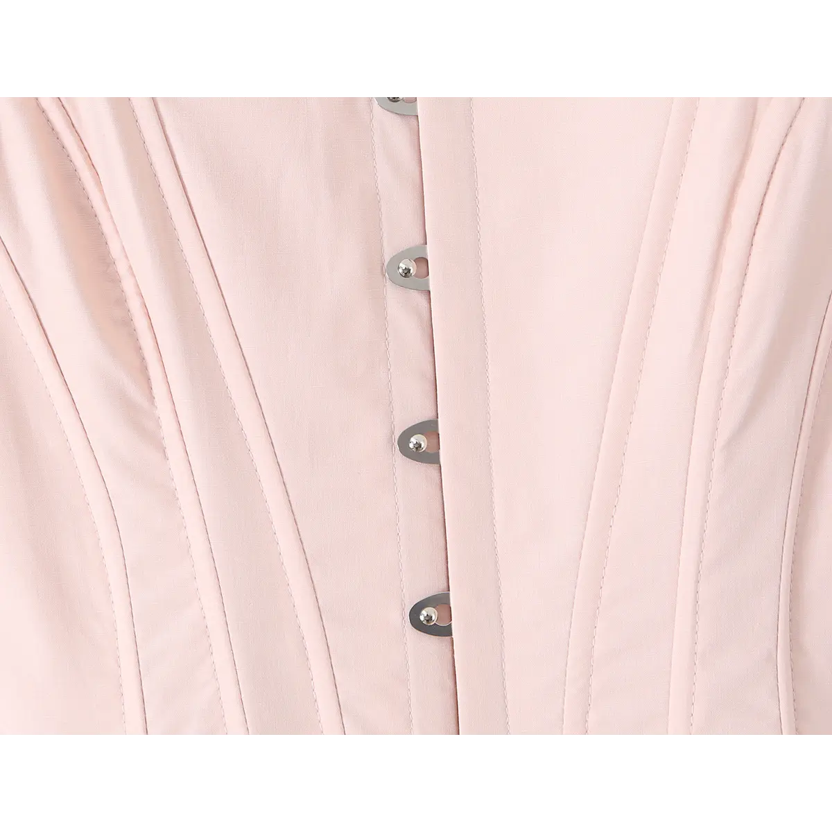 Close-up of the front metal eyelets and vertical boning on a light pink corset dress.
