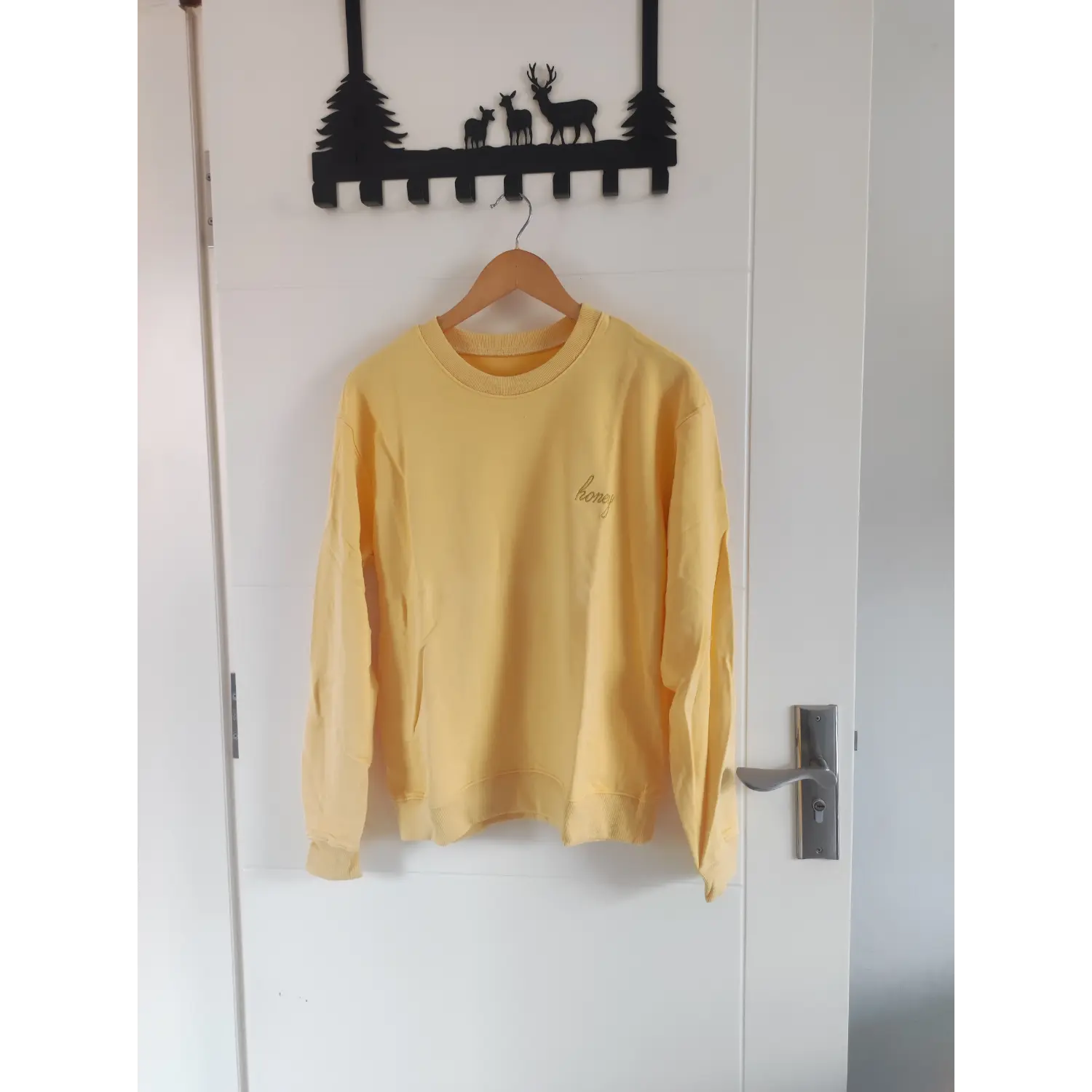  Front hanging shot soft yellow honey embroidered crewneck sweatshirt on wooden hanger