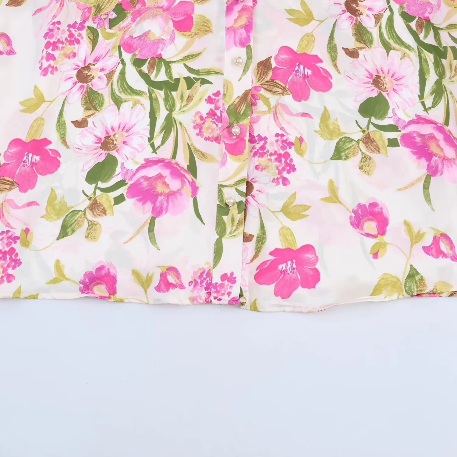 Lower front hem flat shot, full vertical pearl button row, straight finished bottom hem
