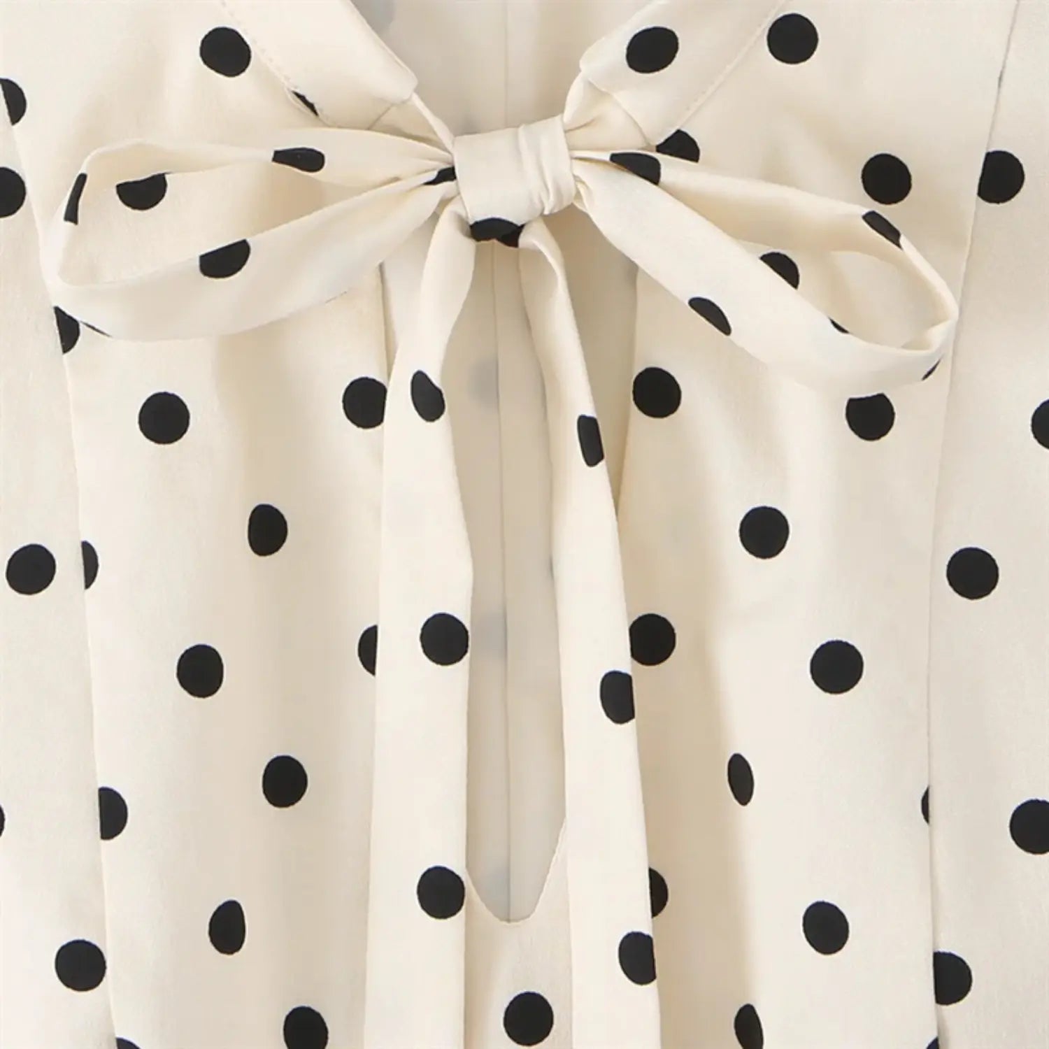 Extreme close-up of neck bow knot, wide matching fabric tie strips, natural soft folds, fine twill woven texture