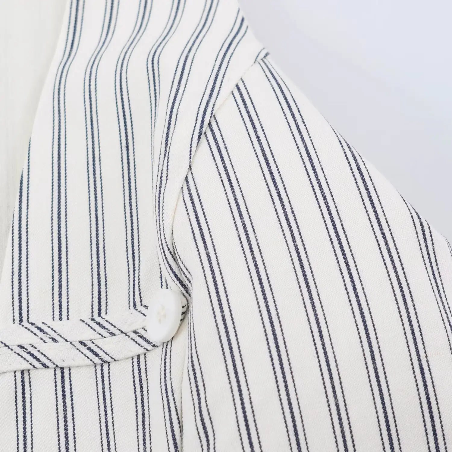 Front V-neck decorative button strip seam shot, fine serged stitching matching dress fabric