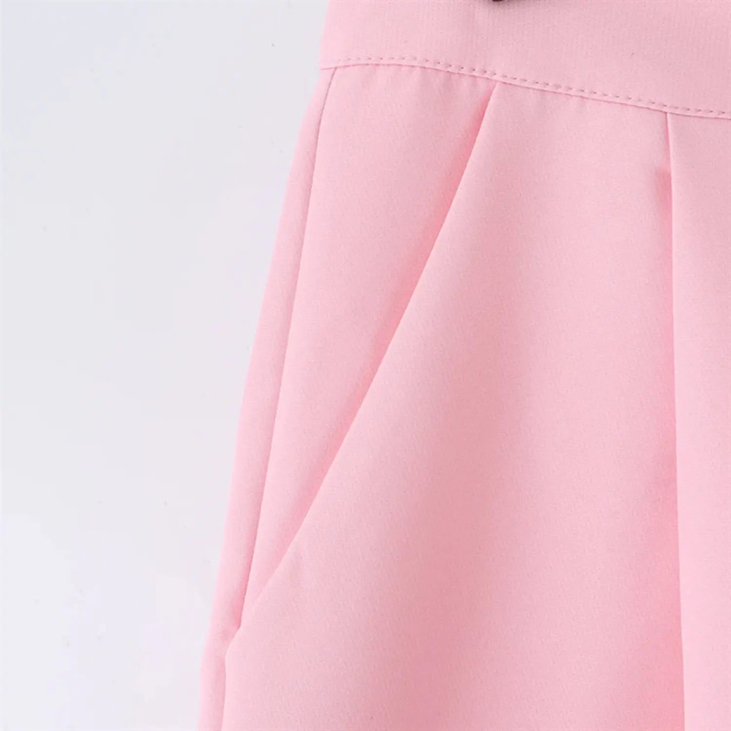 Front wrap panel partial view, overlapping fold pleats, side waist shaping darts, smooth pink suiting drape