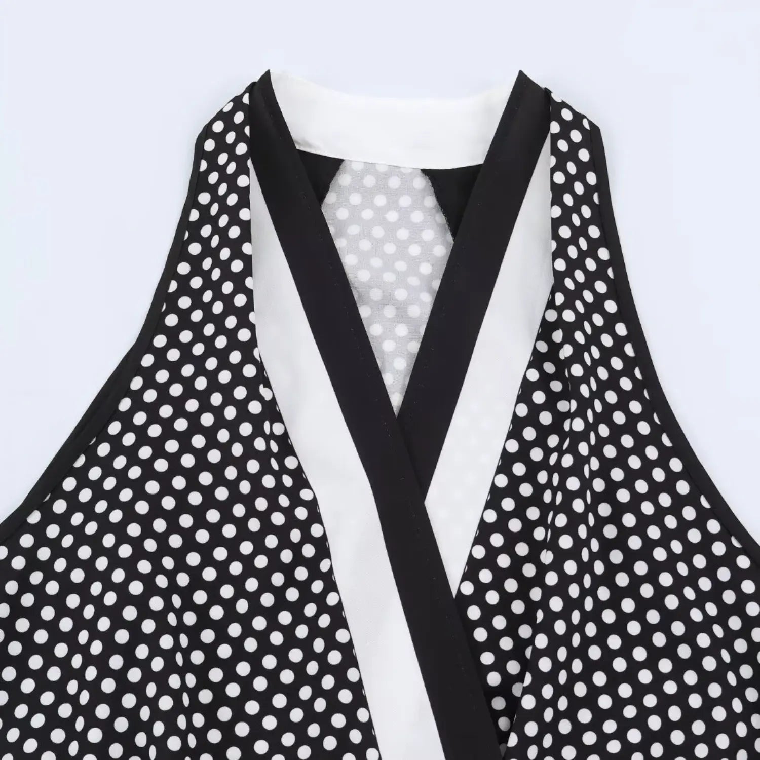 Front wrap V neck partial close-up, black & white contrast piping trim, polka dot woven fabric texture