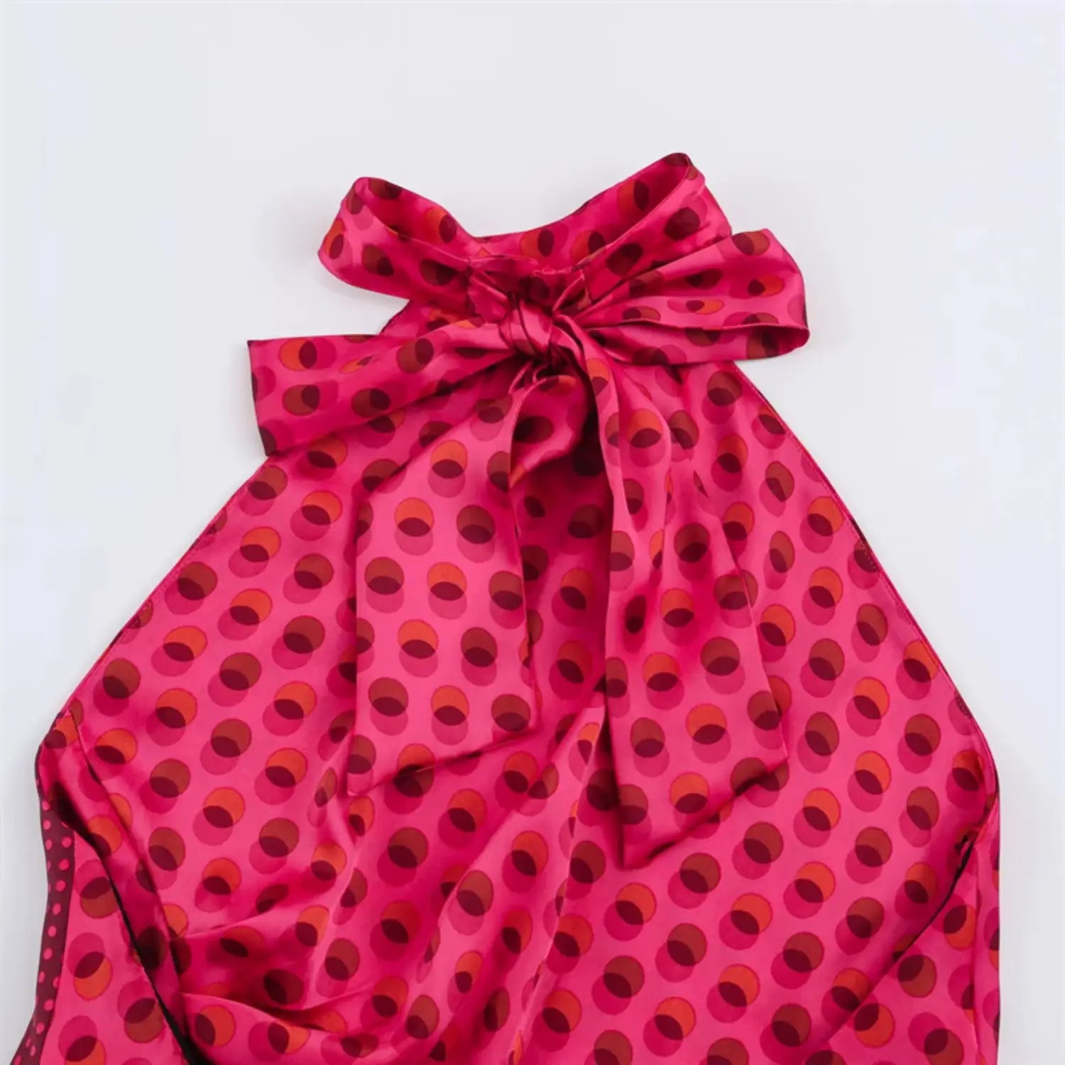 Upper back halter bow close-up, oversized self-fabric tied bow, two-tone circle dot satin print, gathered neck pleats