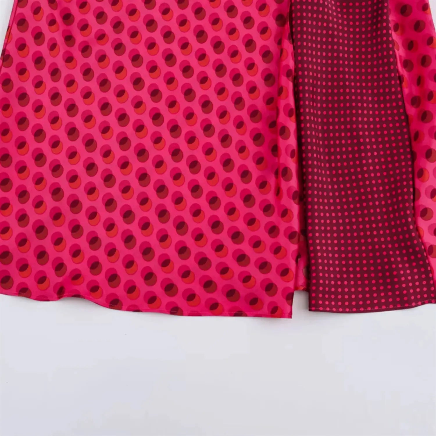 Two fabric panels flat lay comparison, left main large circle dot outer fabric, right dark mini polka dot lining fabric, glossy silky satin texture, two matching fuchsia tone prints