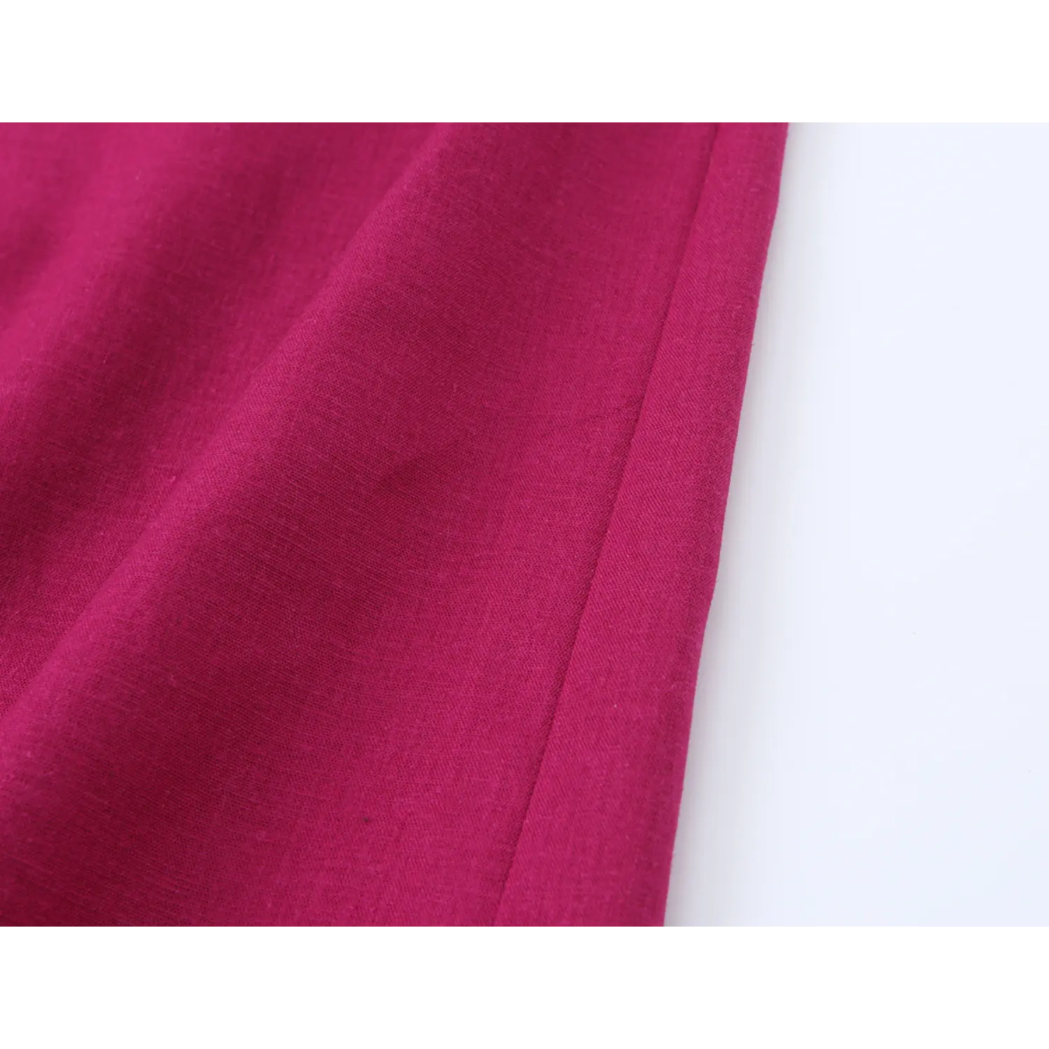 Close-up stitching and texture of side seam on fuchsia woven fabric dress