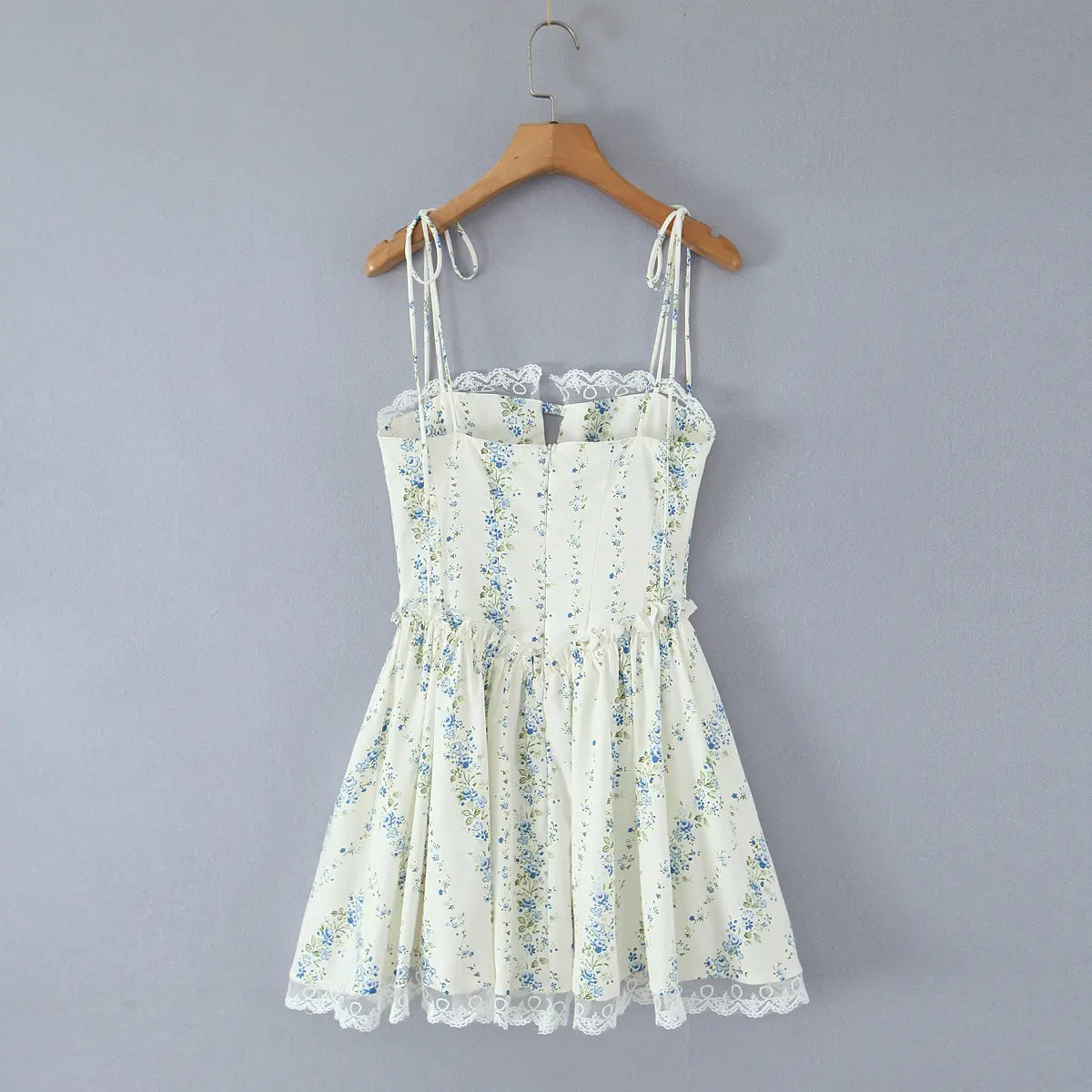 Full back view of a cream blue floral mini dress, showing the tie straps, lace hem, and hidden zipper.