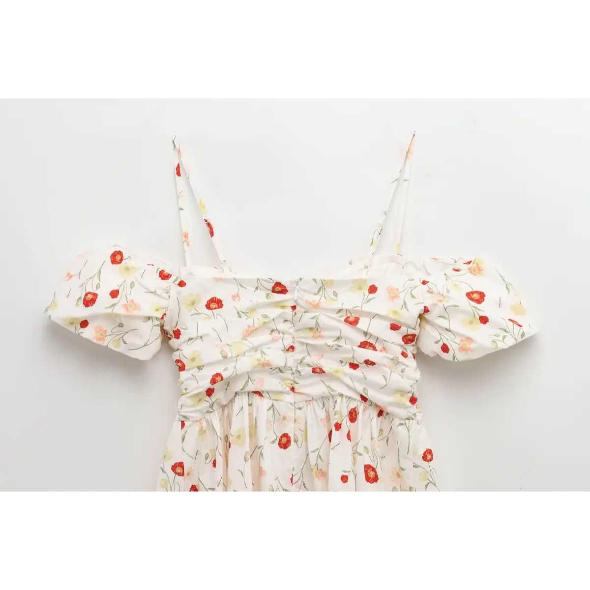 Full back view of a white poppy-print dress, showing the center zipper and gathered bodice.