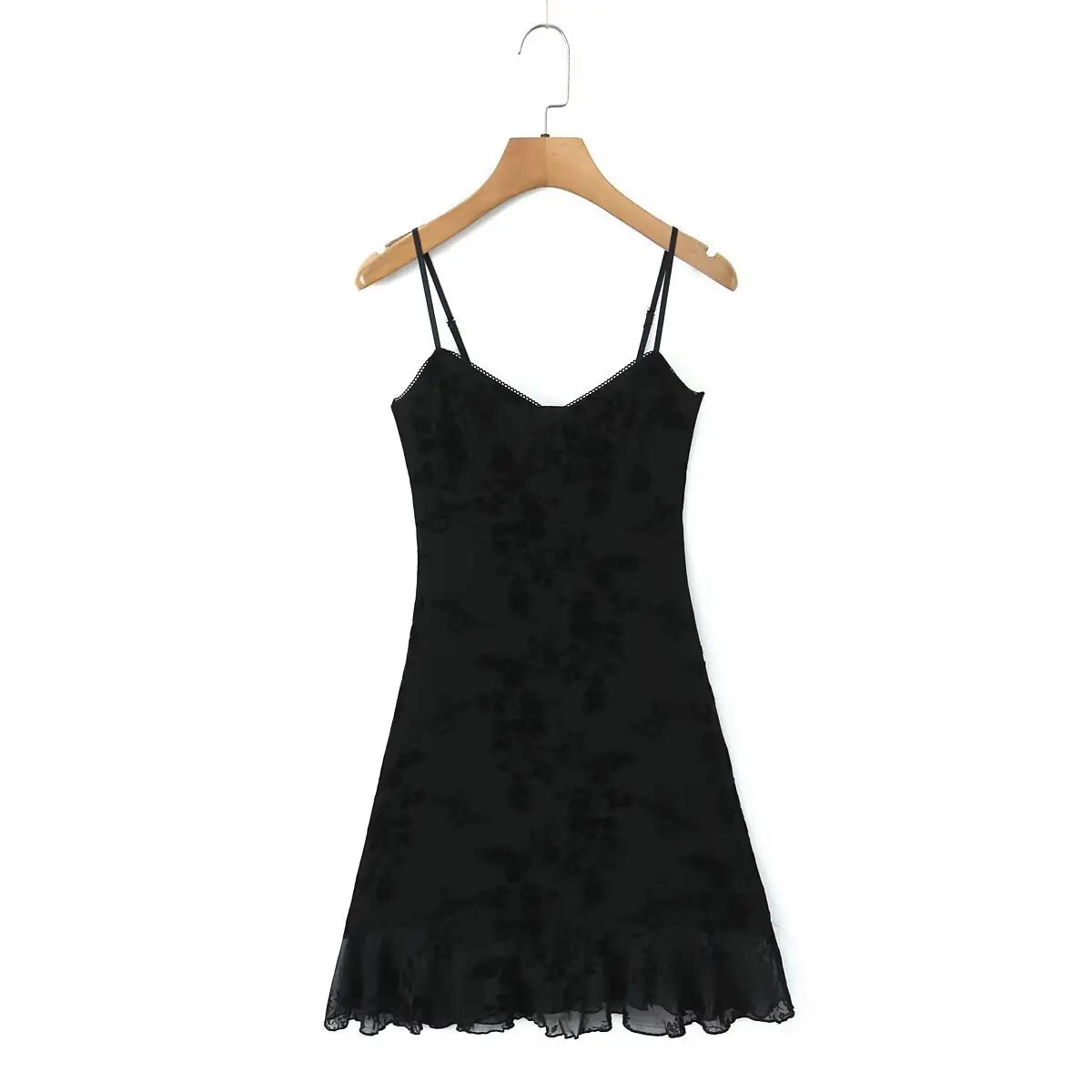 Full front view of a black flocked floral slip dress on a wooden hanger, showing the sweetheart neckline, fitted silhouette, and sheer ruffled hem.