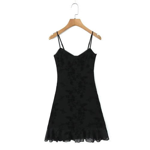 Full front view of a black flocked floral slip dress on a wooden hanger, showing the sweetheart neckline, fitted silhouette, and sheer ruffled hem.