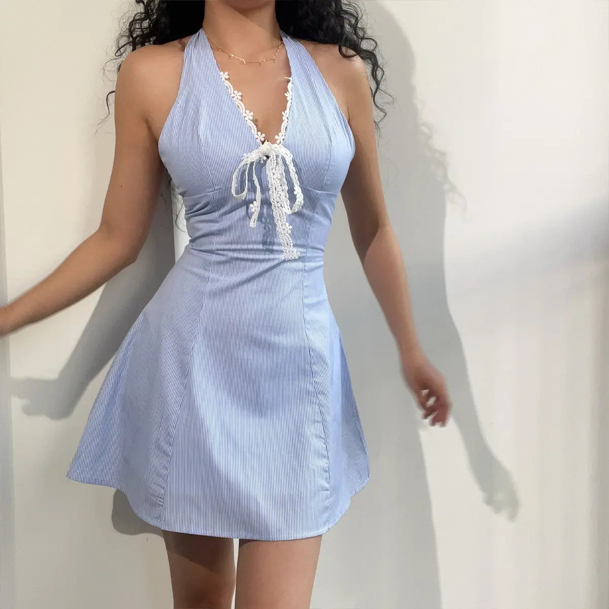  Full front view of a blue and white striped halter mini dress, showcasing the A-line skirt and lace-trimmed neckline.