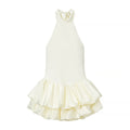 Full front view of a cream halter neck mini dress, featuring a high neckline, fitted bodice, and double-layered ruffled skirt.