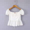 Close-up of the puff sleeve on a white off-shoulder peplum top, showing the ruffled elasticated edge and gathered construction.