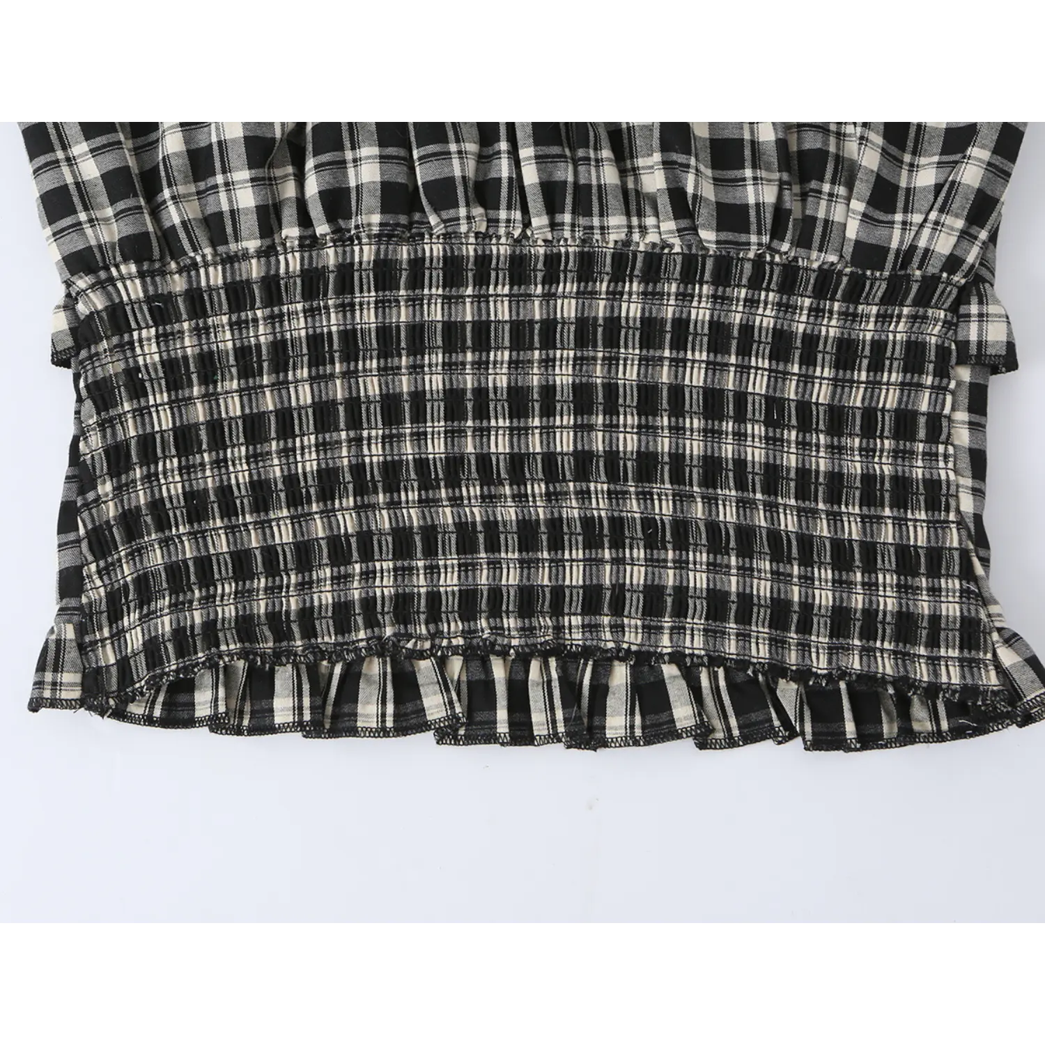 Macro close-up all-over elastic smocked waistband on plaid top, tight gathered stretch stitching, black cream check woven material