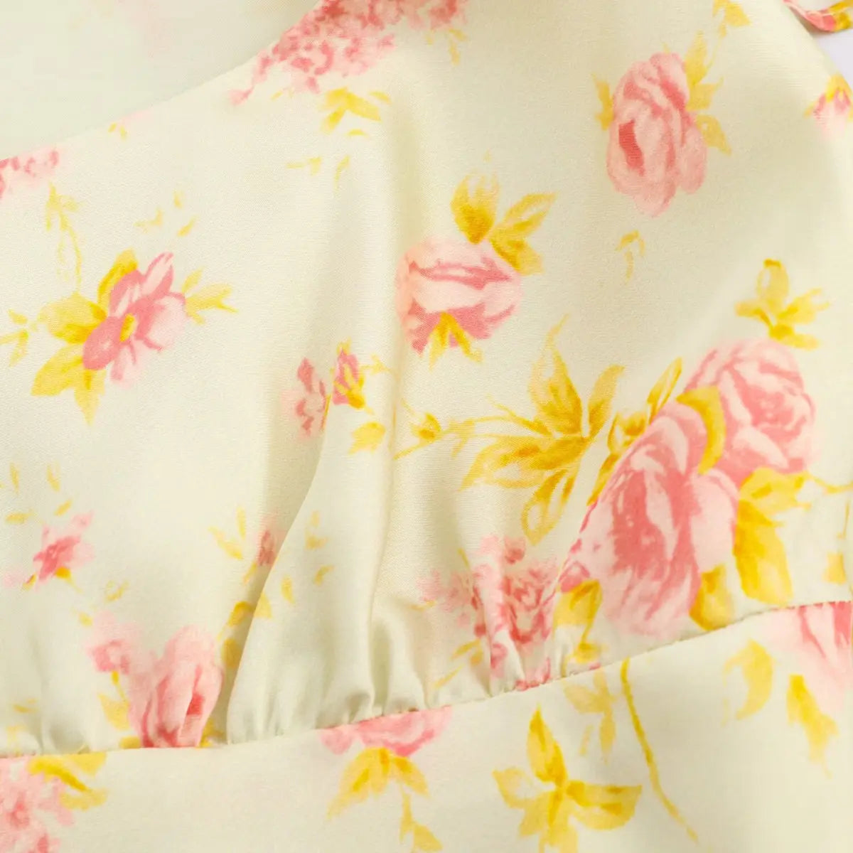 Close-up of the gathered bust on a pale yellow floral dress, highlighting the stitching and floral print.