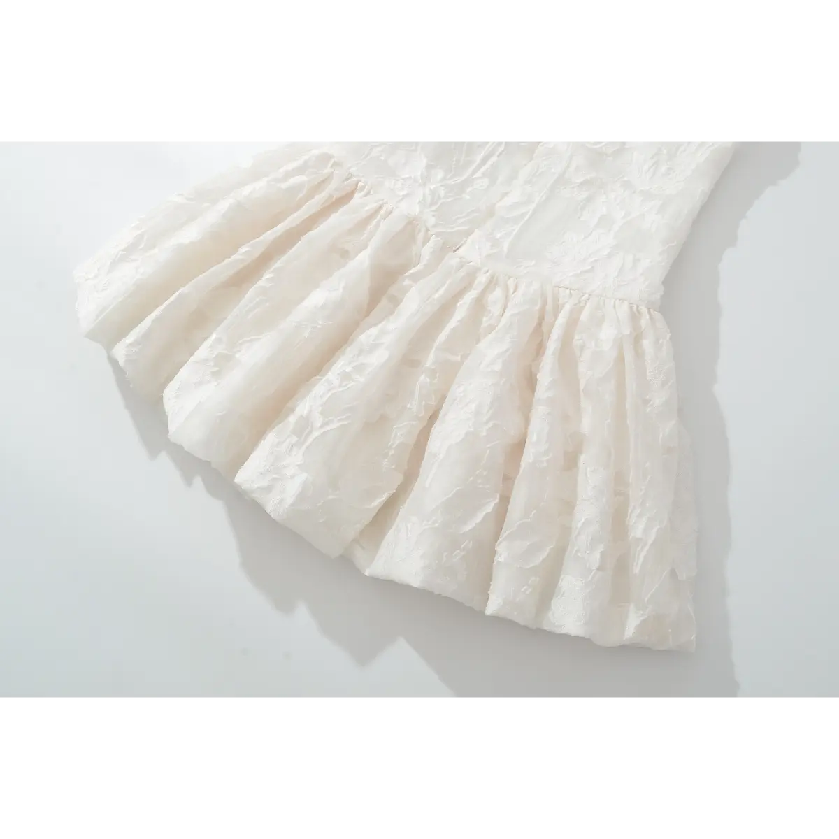 Closeup of ruched flare skirt on raised flower woven fabric