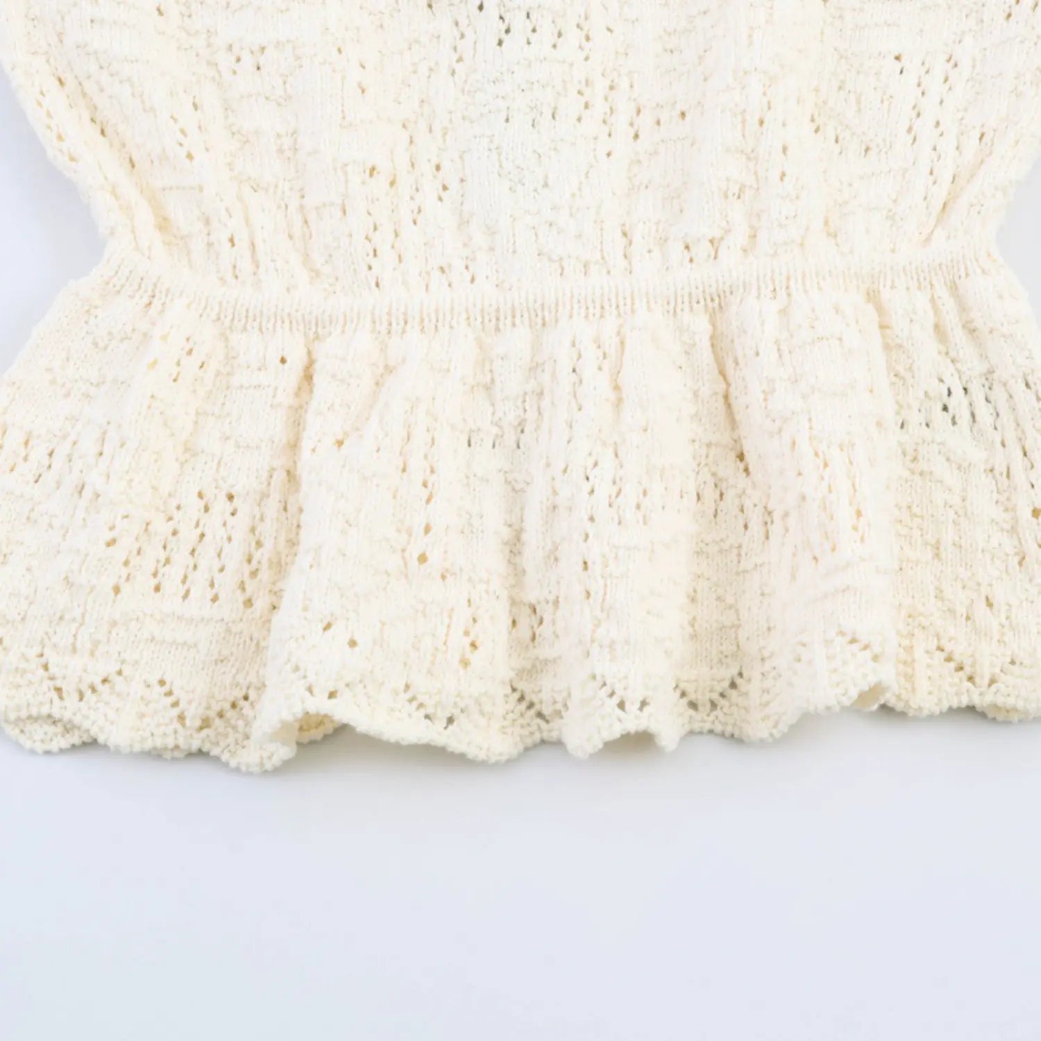 Closeup finished scalloped knit hem on peplum skirt