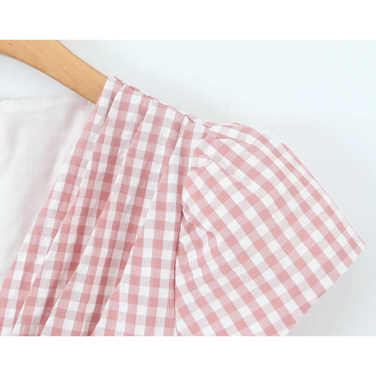 Closeup of ruched puff short sleeve on pink check woven fabric