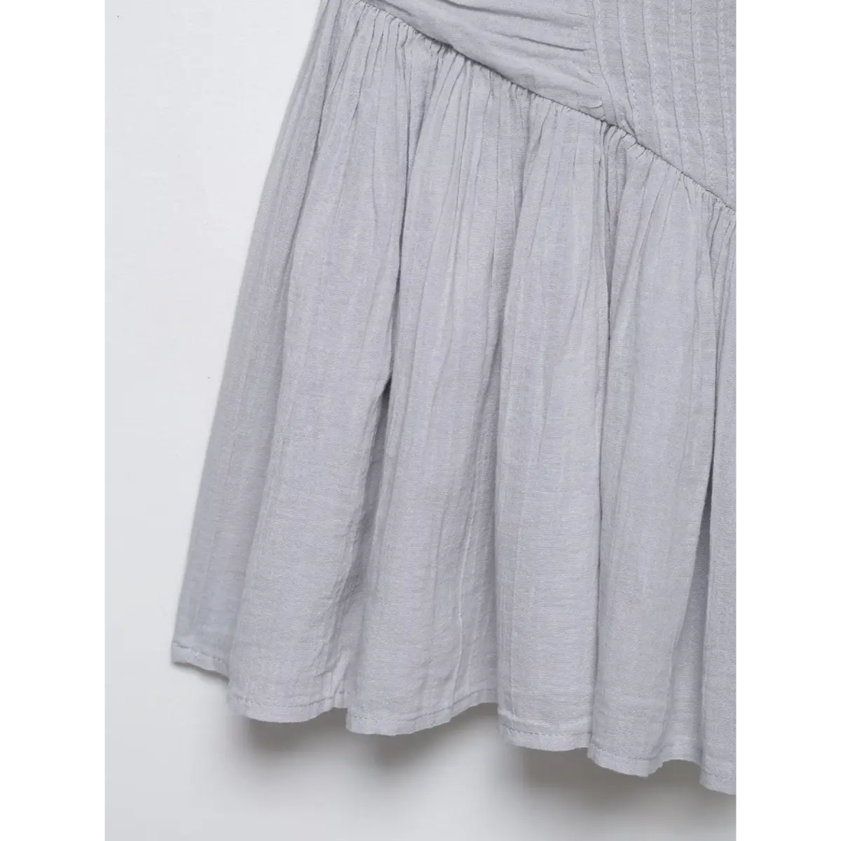 Close-up of the ruffled cami strap on a gray dress, highlighting the delicate frill and stitching.