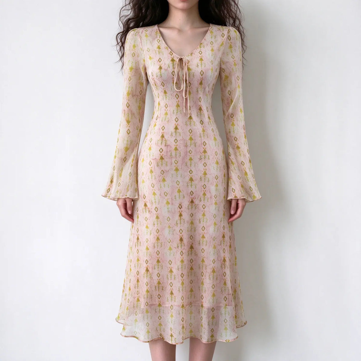 Model wearing geometric print tie neck bell sleeve dress, front view