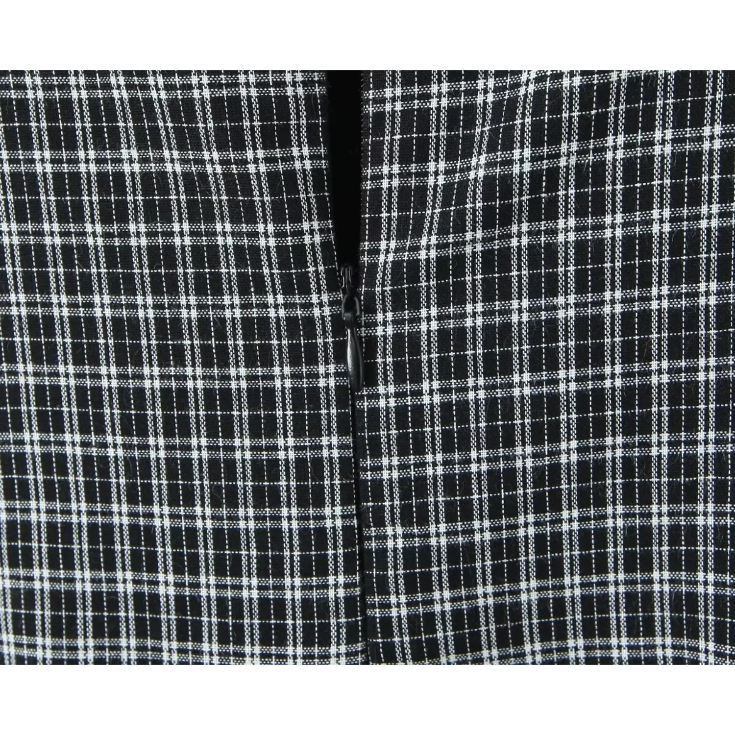 Close‑up invisible back zipper on black‑white gingham dress, plaid woven fabric texture