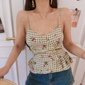 Close up waist detail olive white check floral camisole, vertical shaping seams, flared ruffled peplum hem thin adjustable straps