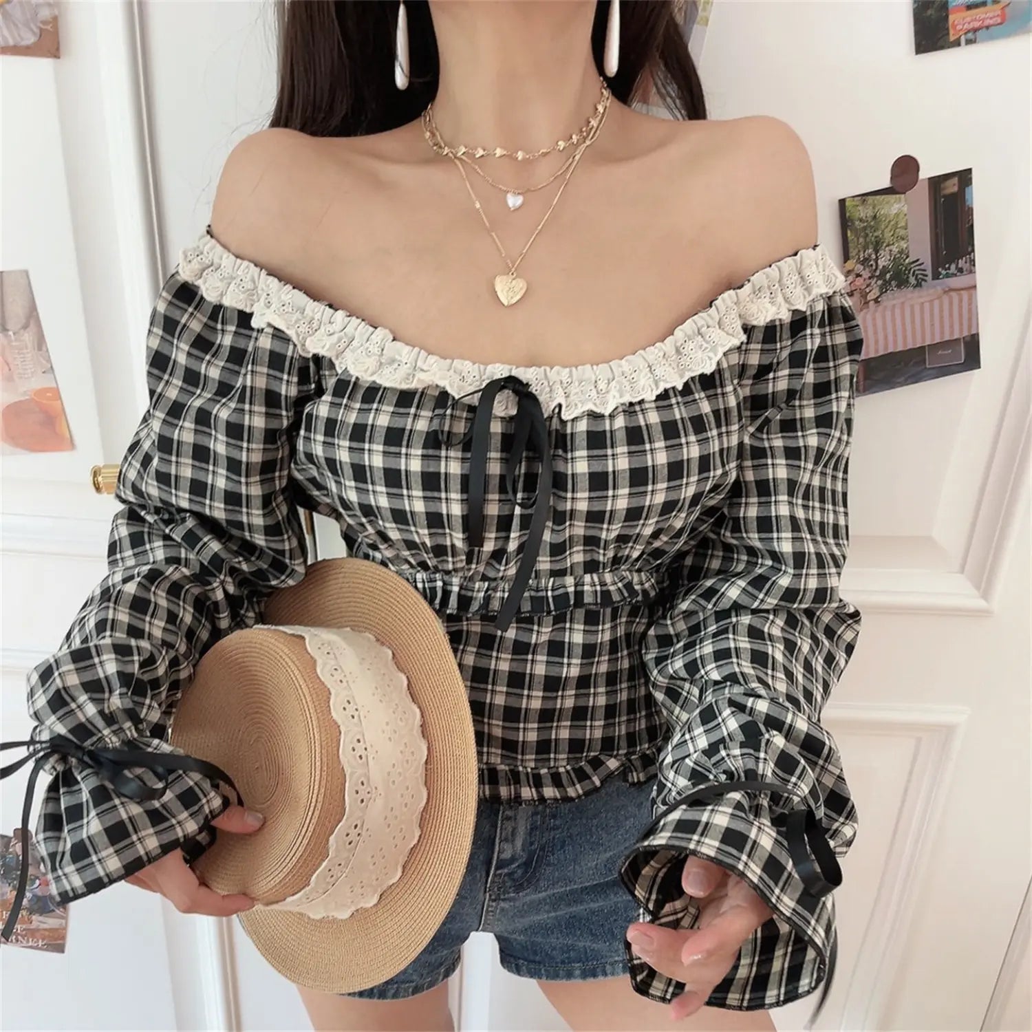 Gingham off shoulder crop top with straw hat model lifestyle shot, lace ruffle cold shoulder adjustable front ribbon tie cropped waist silhouette match denim shorts cottagecore travel outfit display