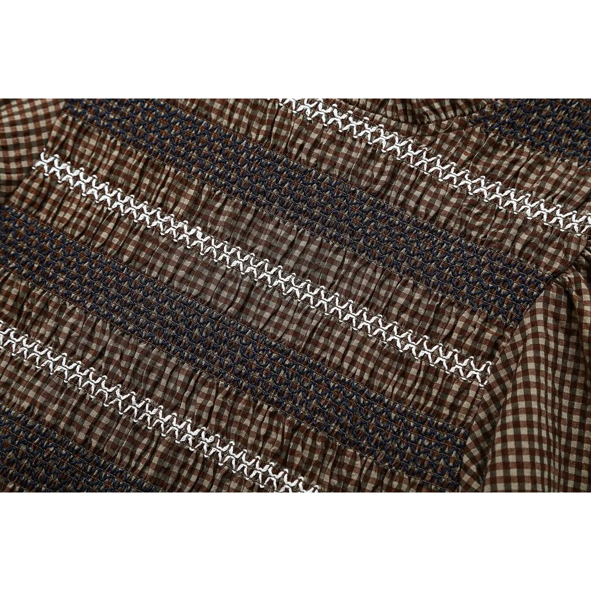 Close-up of chest smocking and white X stitch embroidery