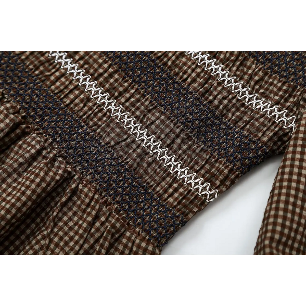 Close-up of navy smocked panel and white zigzag embroidery