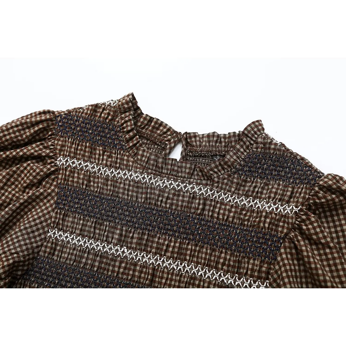 Close-up of ruffled mock neckline and shoulder smocking