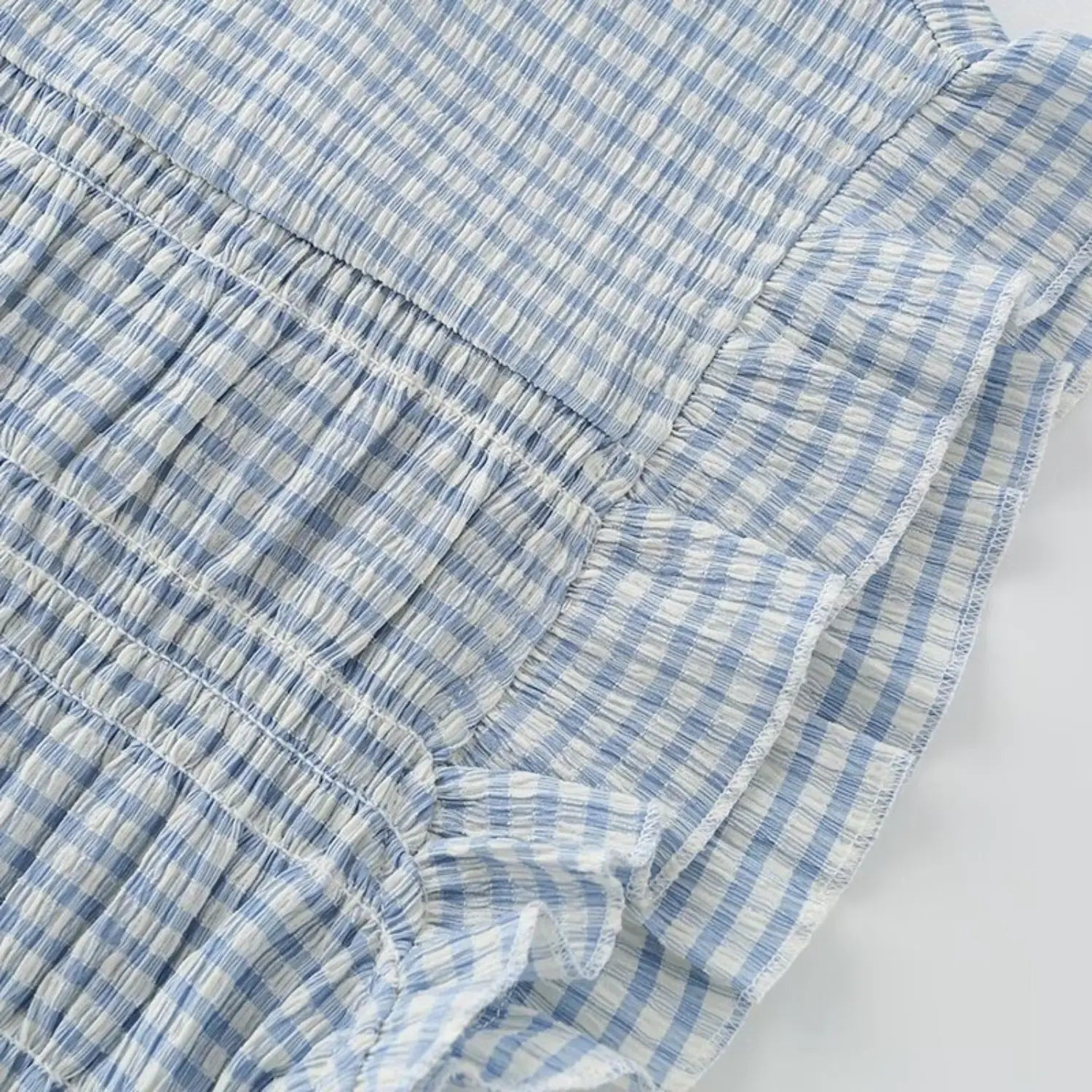 Macro texture shot flutter cap sleeve ruffle, layered frill edge, crinkle gingham fabric weave, elastic smock seam transition detail