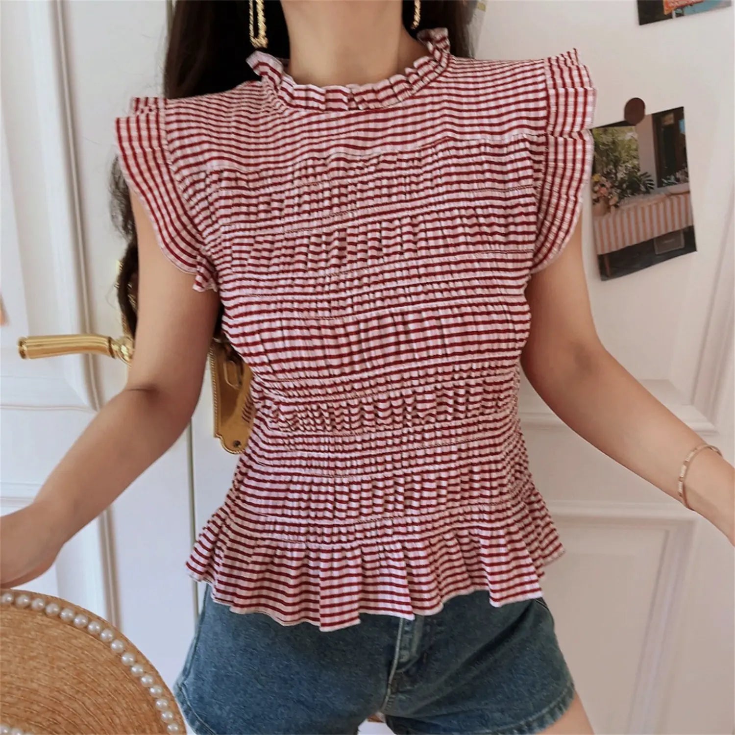 Side view model wearing wine red tiny gingham smocked top, full body elastic ruched torso, ruffle cap sleeve outline, flutter peplum waist hem, slim cropped silhouette