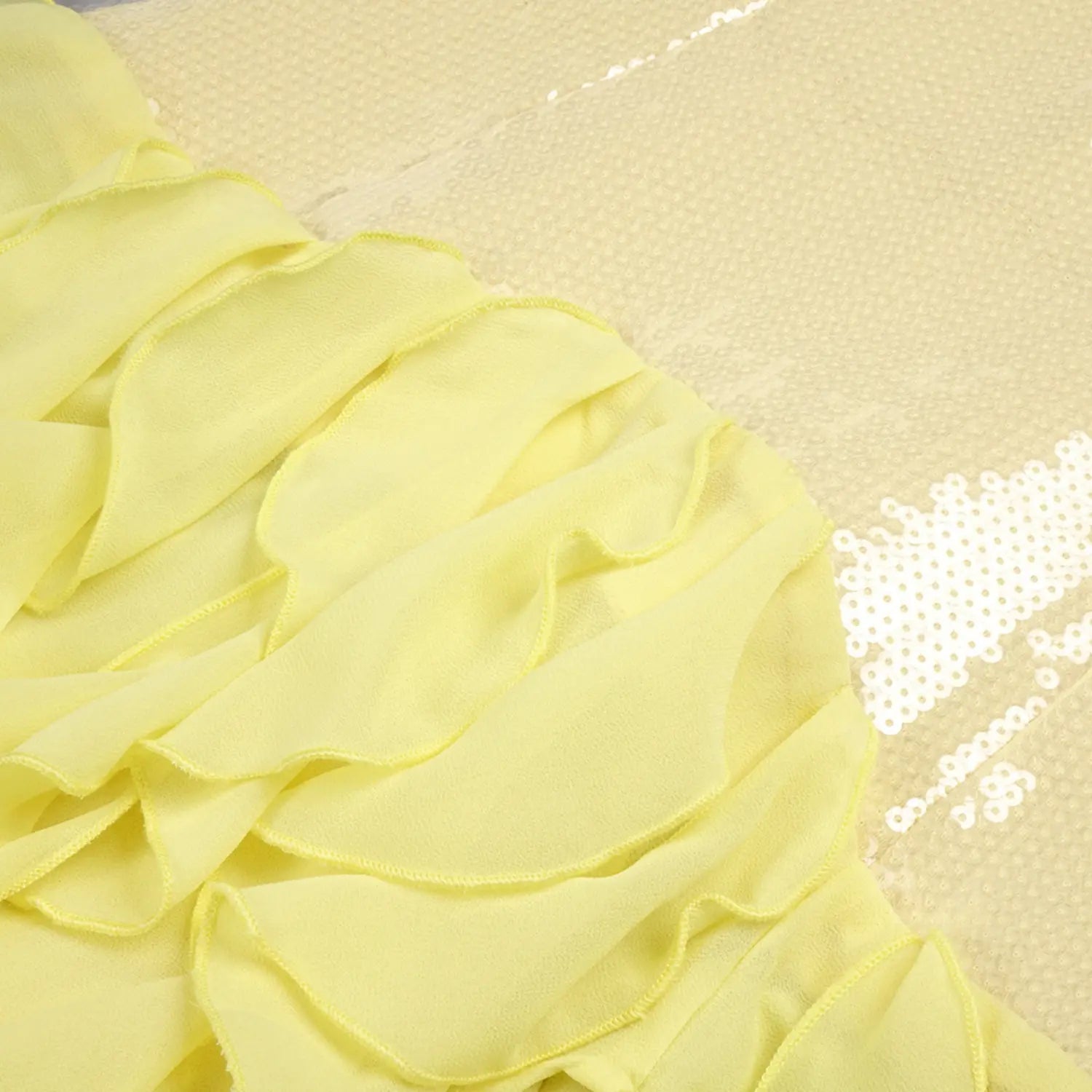 Macro close-up of tiered yellow chiffon ruffle layers, lightweight sheer fabric with neat finished narrow hem stitching