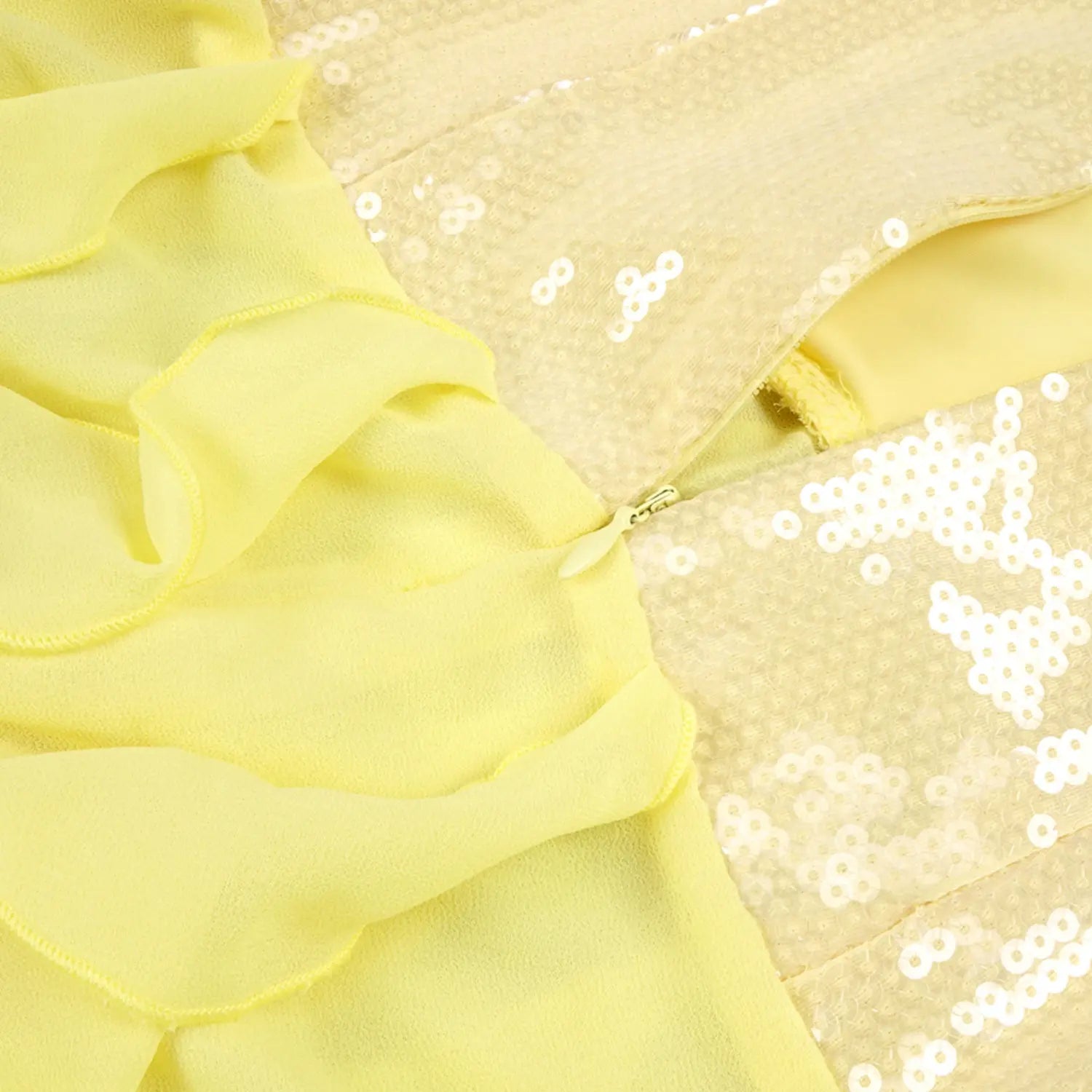 Close-up shot of invisible center back zipper on yellow strapless gown, glossy sequin bodice spliced with layered sheer chiffon ruffle skirt fabric