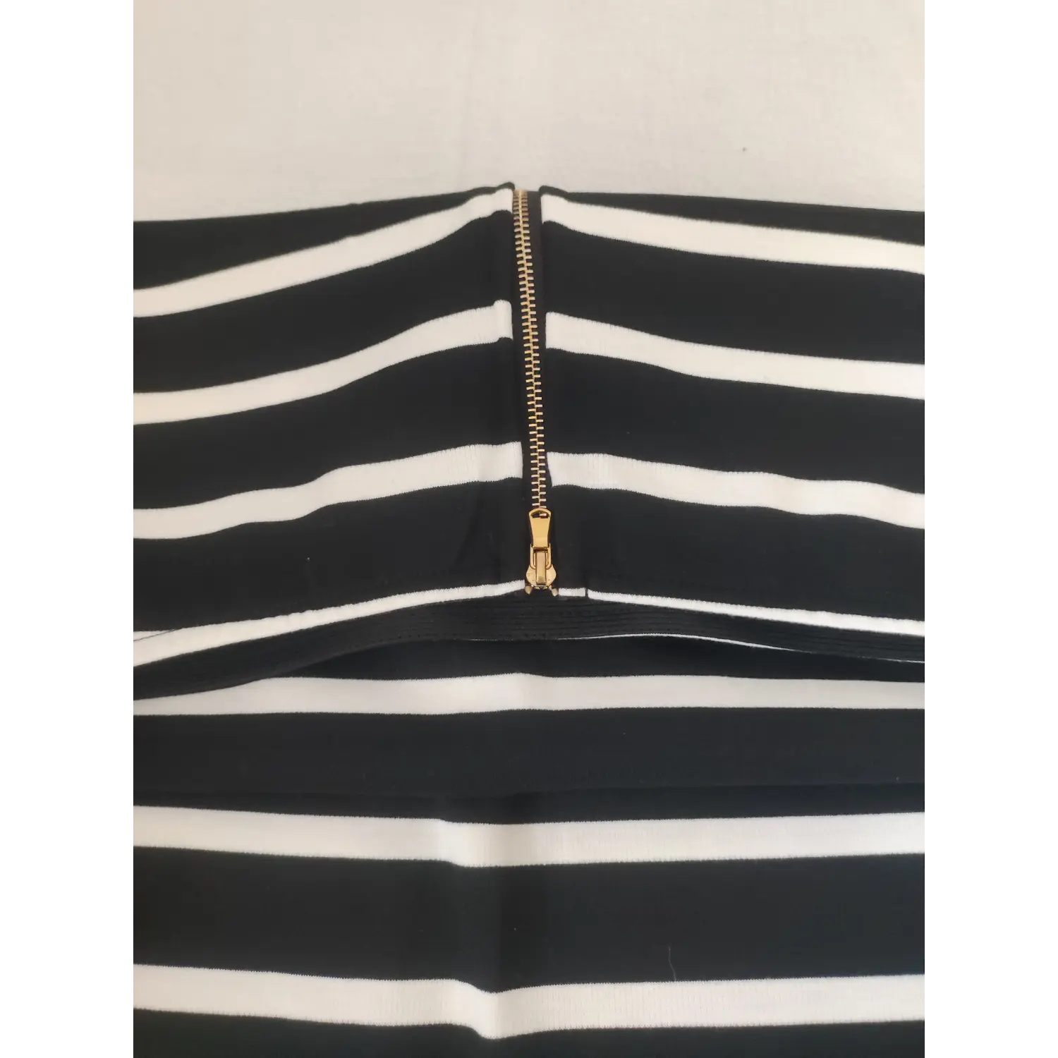 Close up waist gold metal zipper on striped pencil skirt