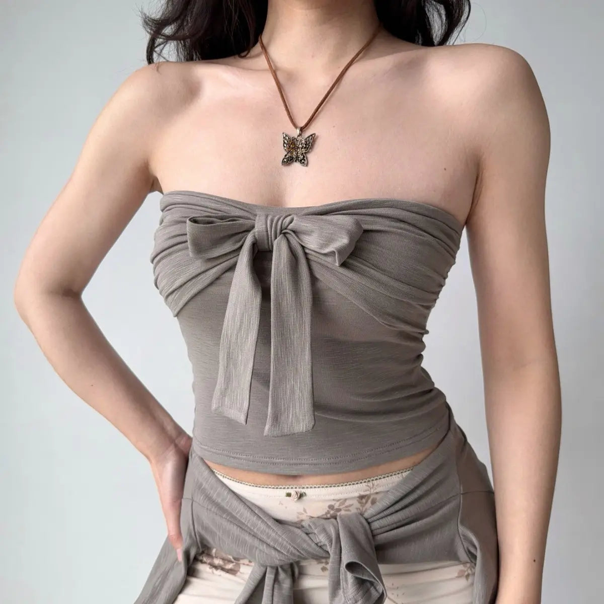 The gray tube top worn alone, highlighting the center bow detail.