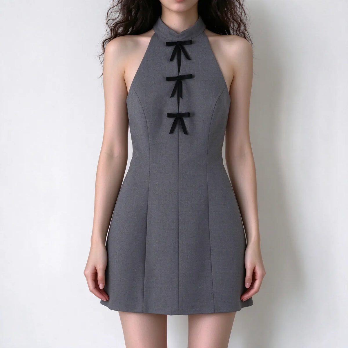Model wearing gray halter neck velvet bow mini dress, front view