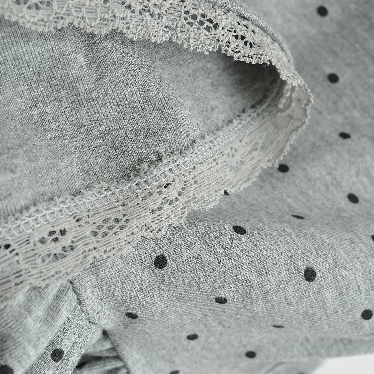 Gray dot knit cami hem lace trim macro shot, hollow lace edge spliced knit fabric stitching texture flat lay detail