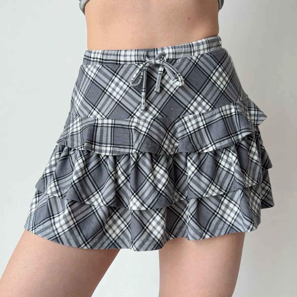 Gray and white plaid tiered ruffle mini skirt with a drawstring waist.